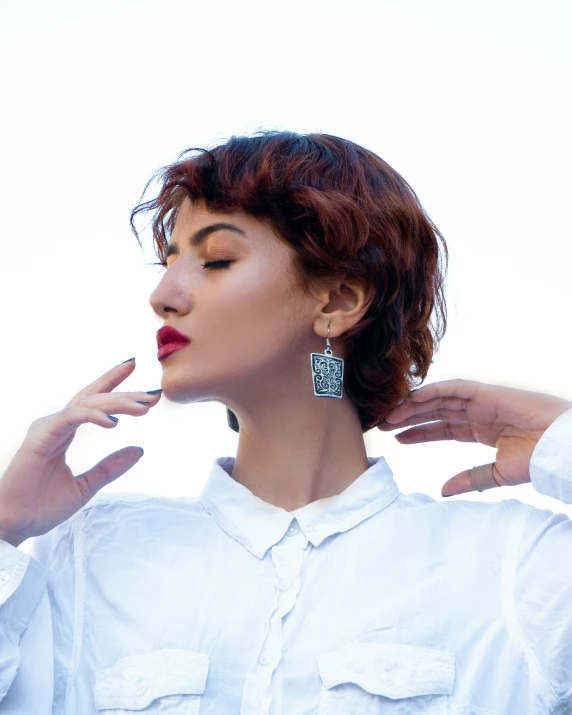 a woman with black and silver earrings poses