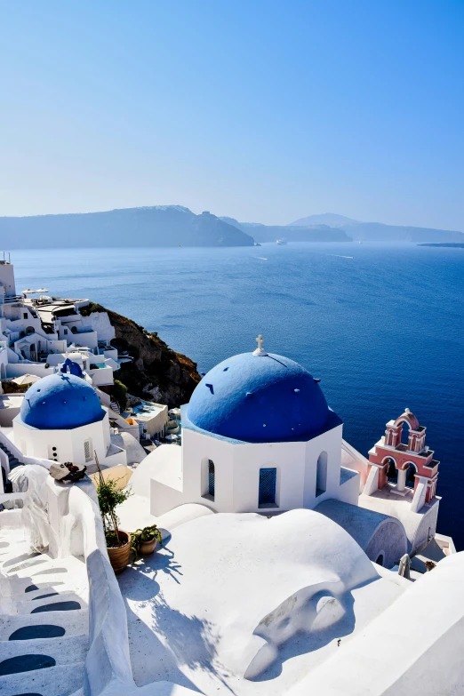 blue and white buildings near the sea with a bright sky