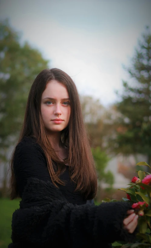 the girl is holding roses in her hand