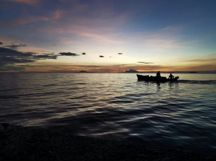 two people on a canoe out at sea under a cloudy sky