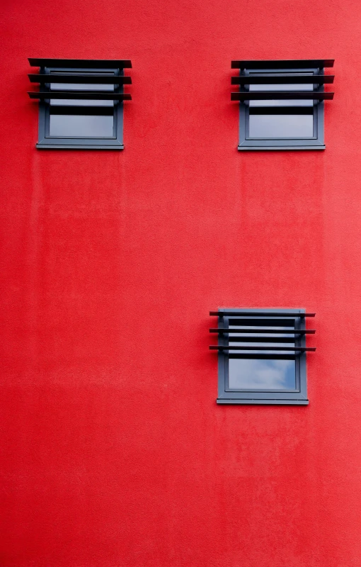 an abstract picture with windows against red wall