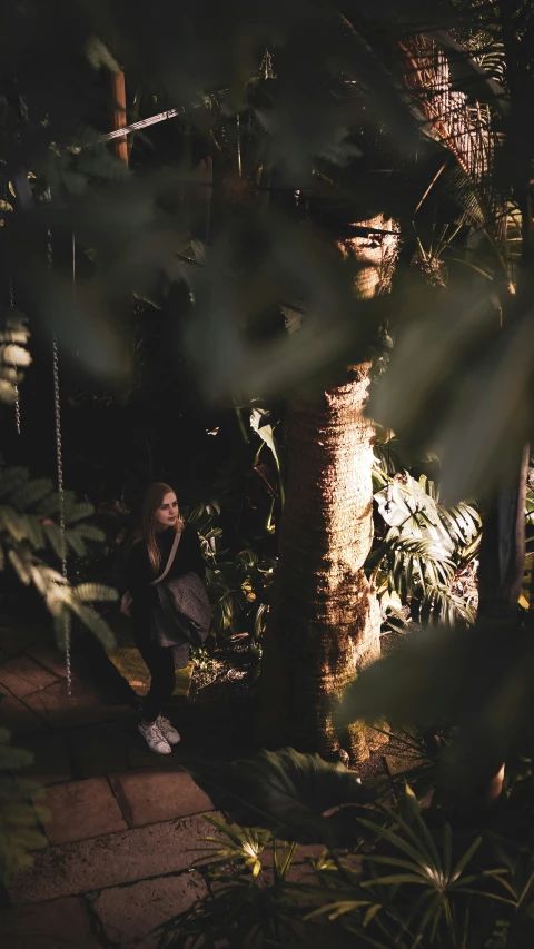 a man kneeling next to a tree near a building