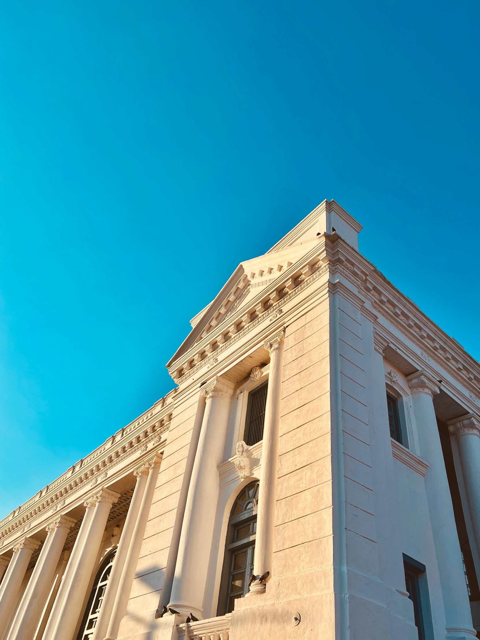 a white stone building with several columns and windows