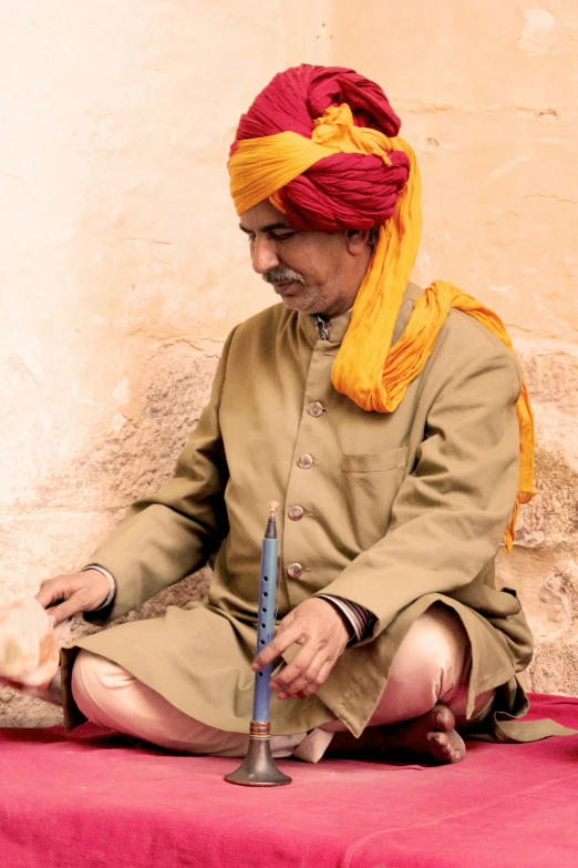 a man sitting on the floor next to a pipe