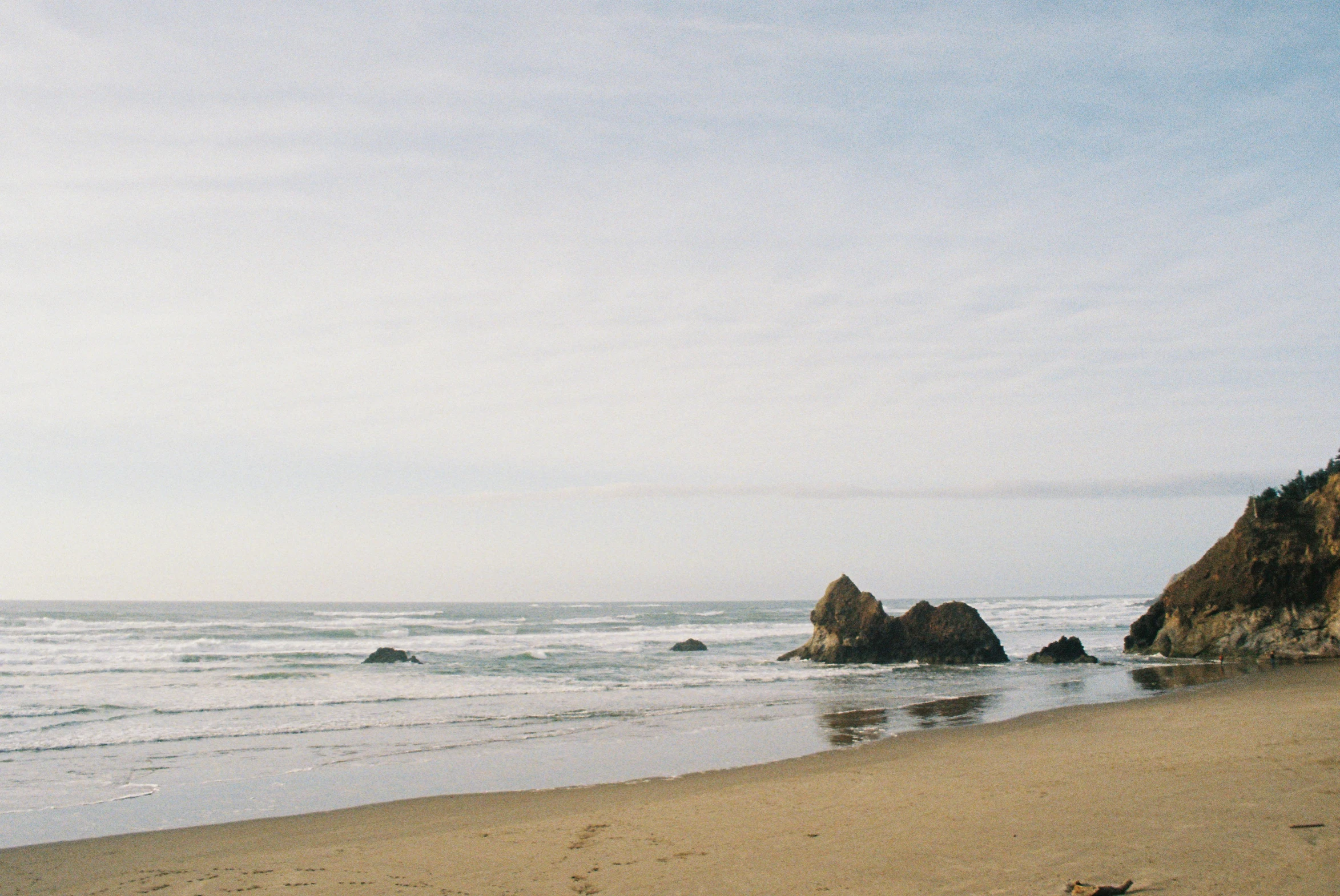 a person laying on the sand near the ocean