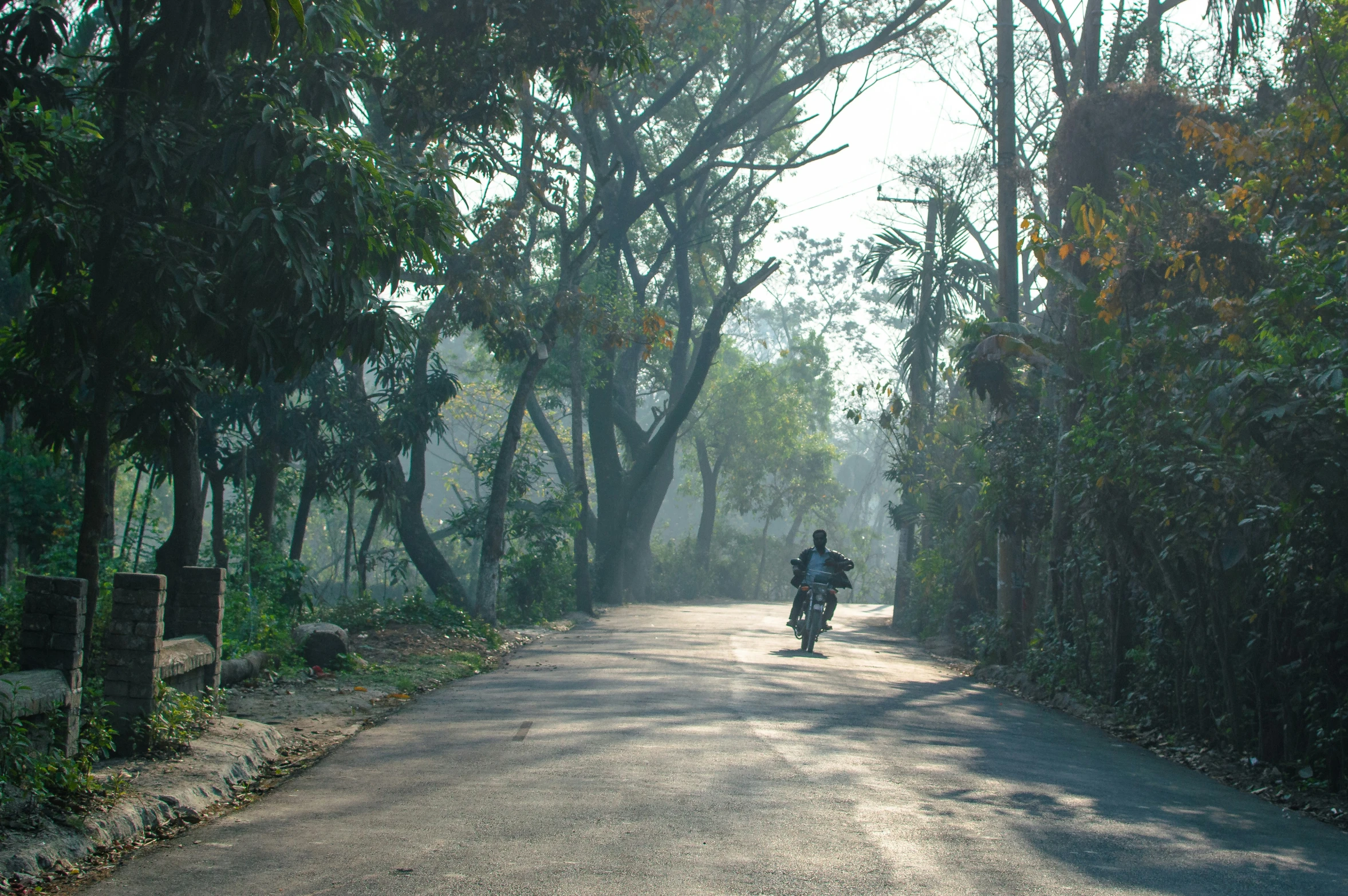 a person riding a motorcycle on a rural road