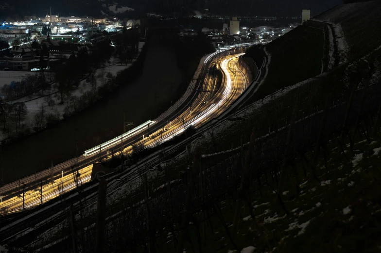 a view from a high rise of a train riding on tracks at night