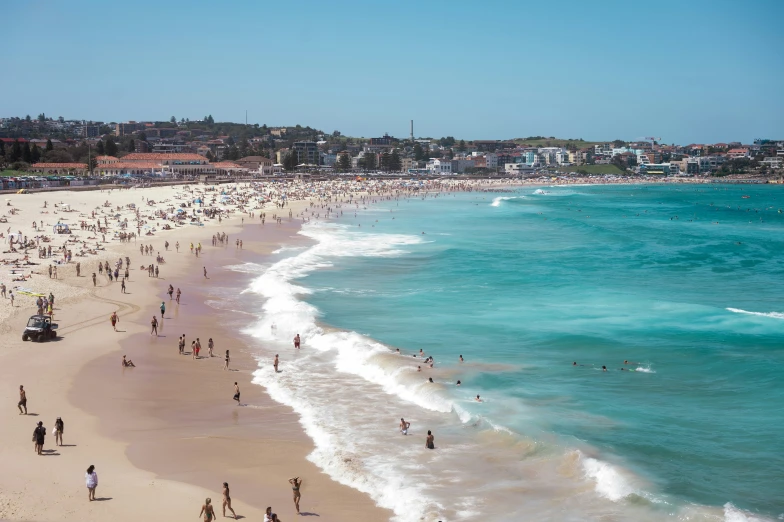 a crowd of people standing on top of a beach