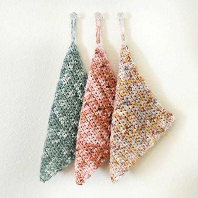 four triangle shaped hand knitted items hanging