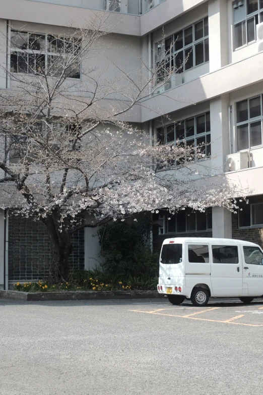 an empty van is parked in front of a white building