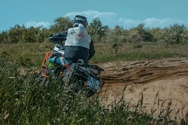 a person on a motorcycle rides in the grass