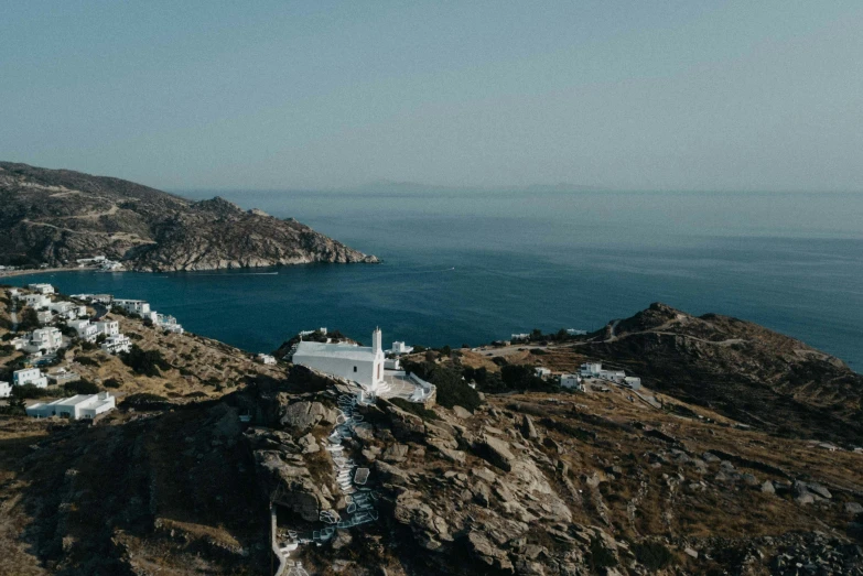 a hill top with a small white church sitting on it's side