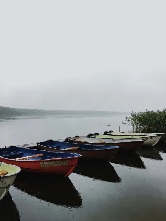 three boats moored to the dock in a lake