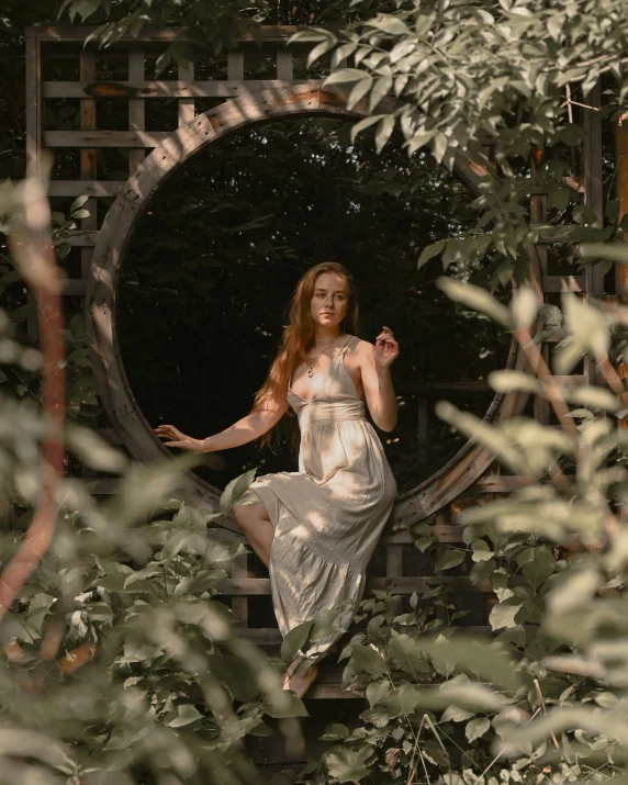 woman in white dress posing near trees in a grotto