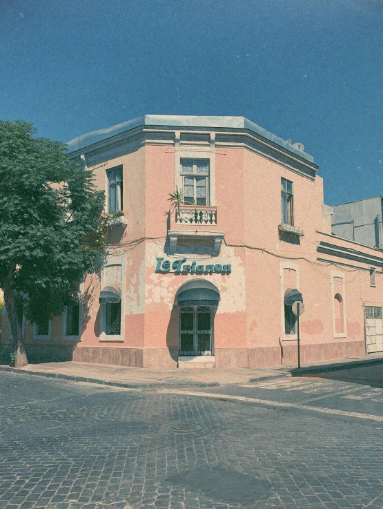 an old building with cobblestone paved street and tall trees