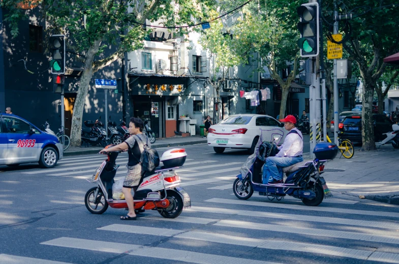 two people on a motorcycle riding down the street