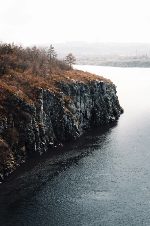 a man that is standing on a hill near some water