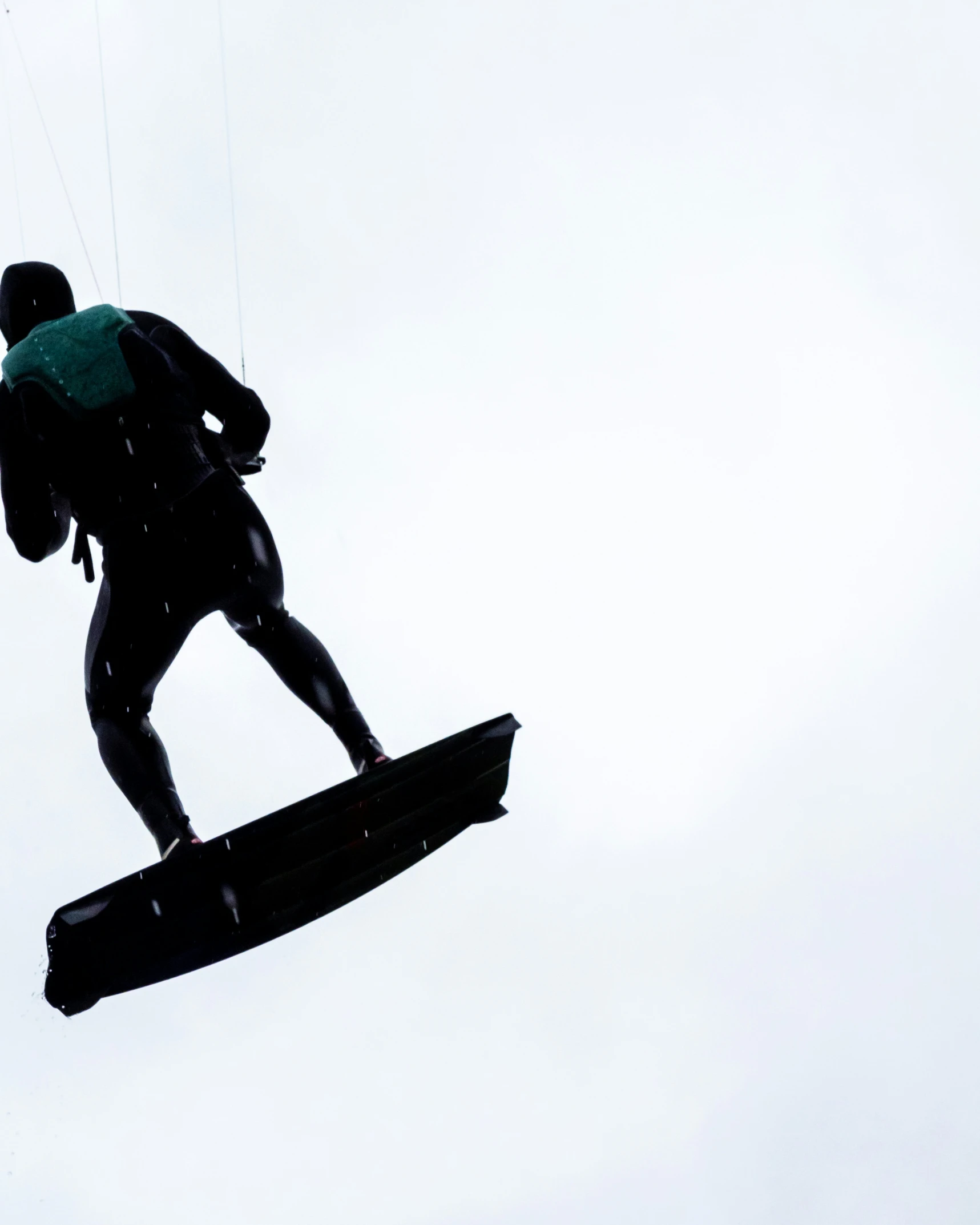 a wake boarder flying through the sky in the day