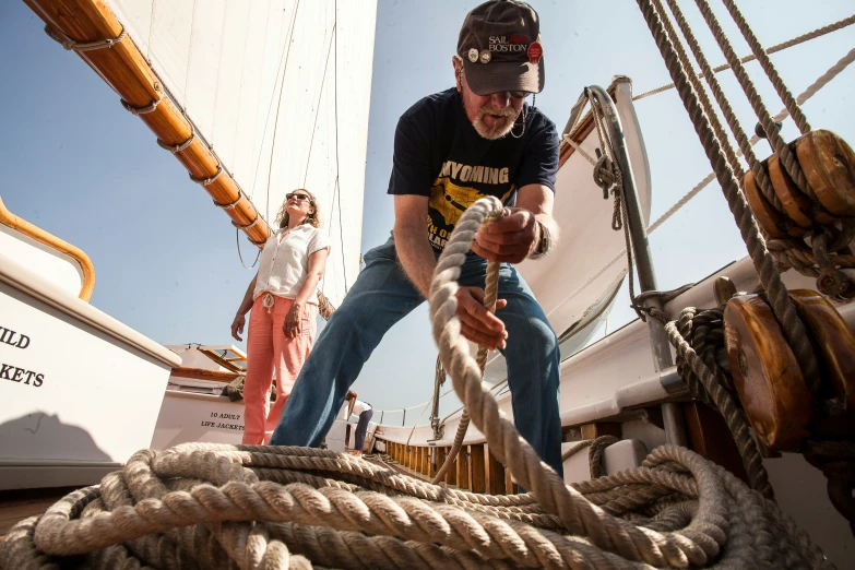 a man holding onto a rope on the side of a boat