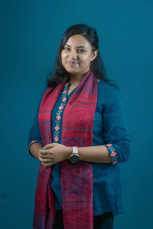 a woman wearing a scarf standing in front of a wall