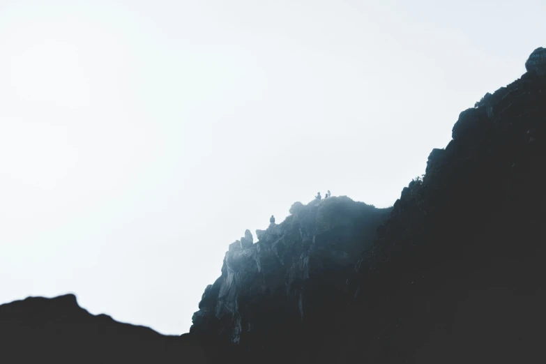 a foggy mountain has steep, narrow rocks