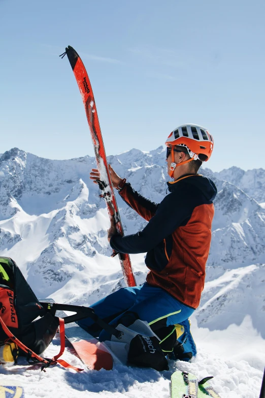 a person holding skis and equipment on a snowy surface