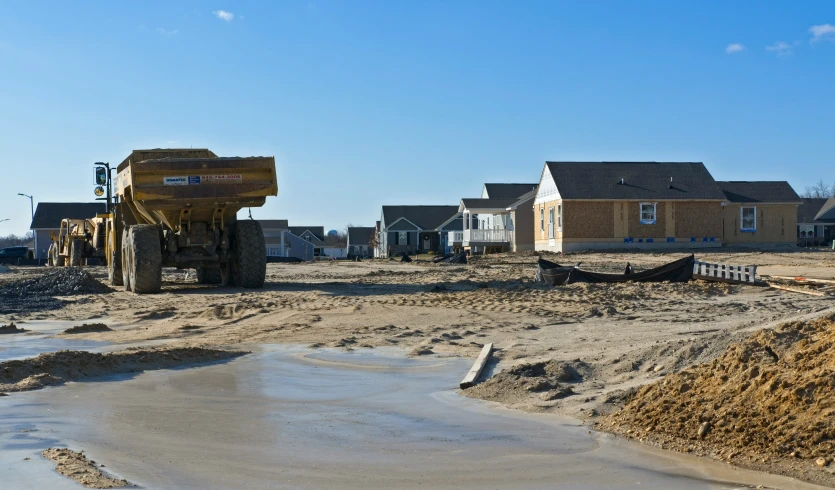 a pile of dirt and a dump truck in the foreground