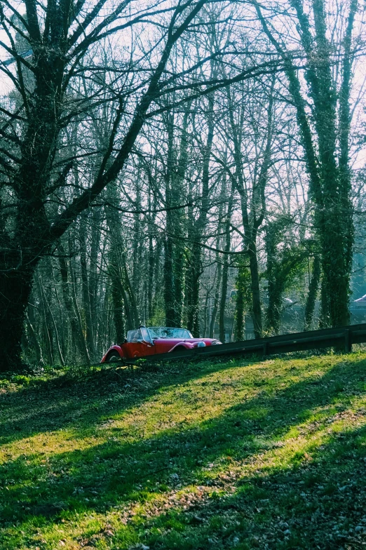 the car is parked in a lot near some trees