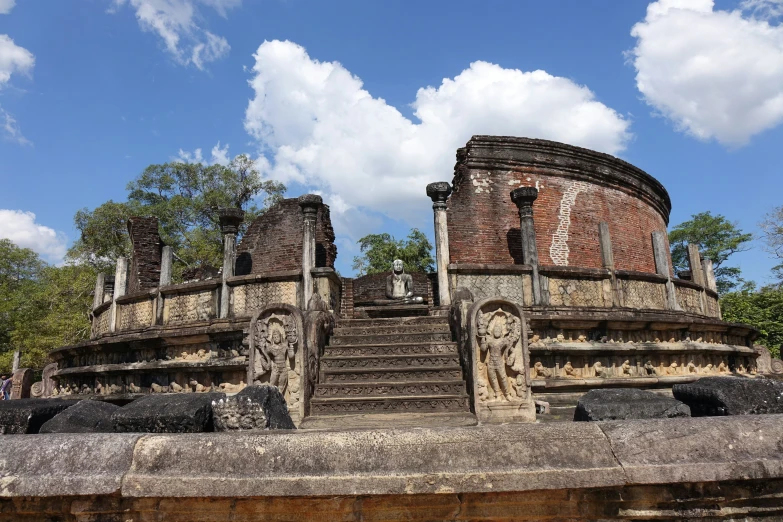 stone statues sitting next to a set of steps on a hill