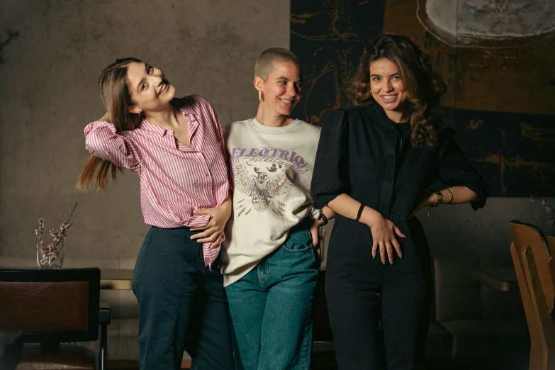 three girls with their arms around each other laughing