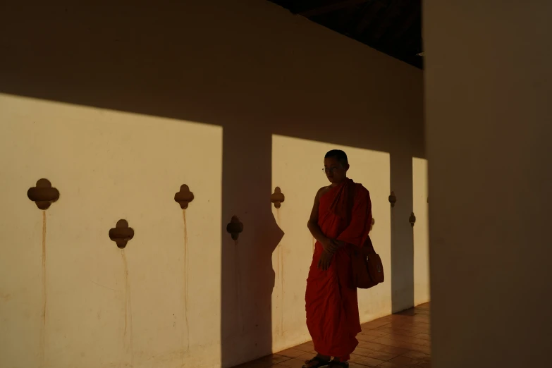 man in red standing by a door near the wall