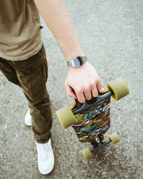 the foot of a young man holding his skateboard