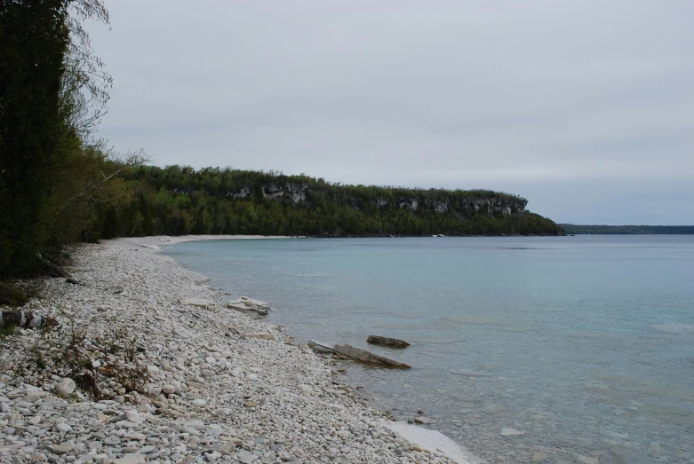 some rocks are next to the beach