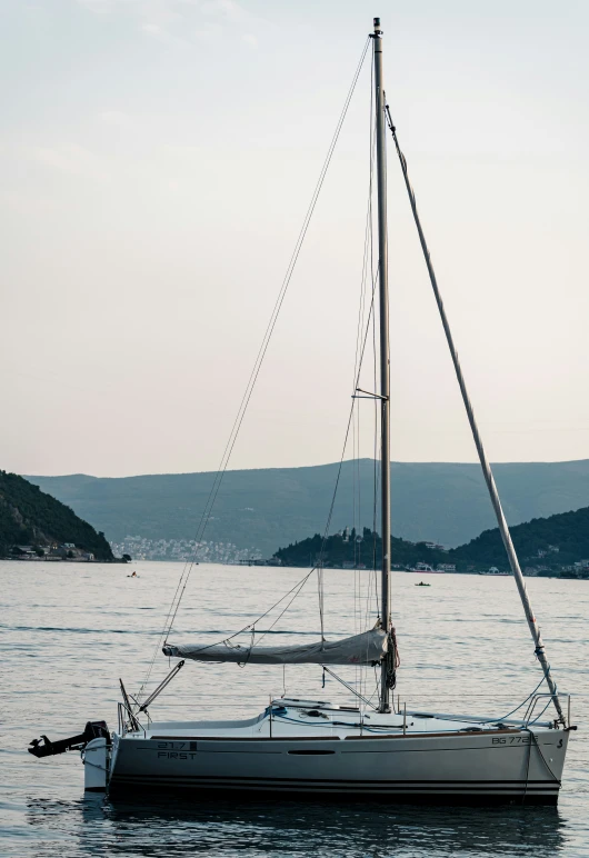 a boat floating on the water in front of a shore