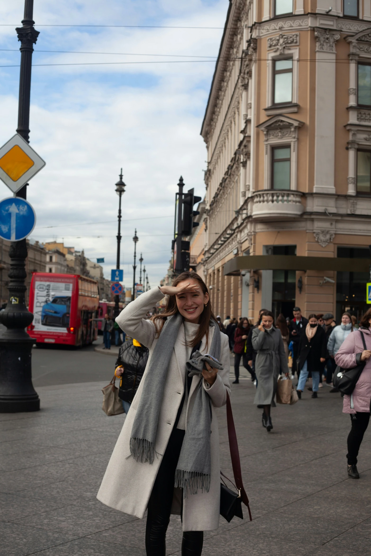 a woman standing on a street near a traffic light