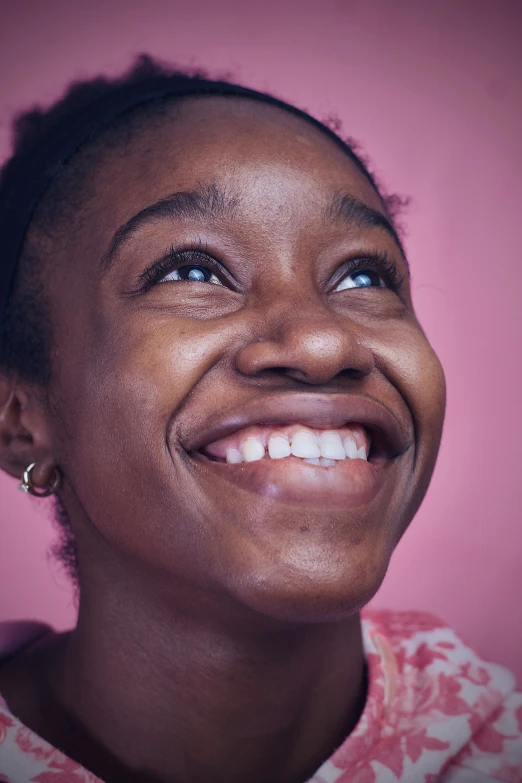 a woman wearing a pink shirt smiling for the camera