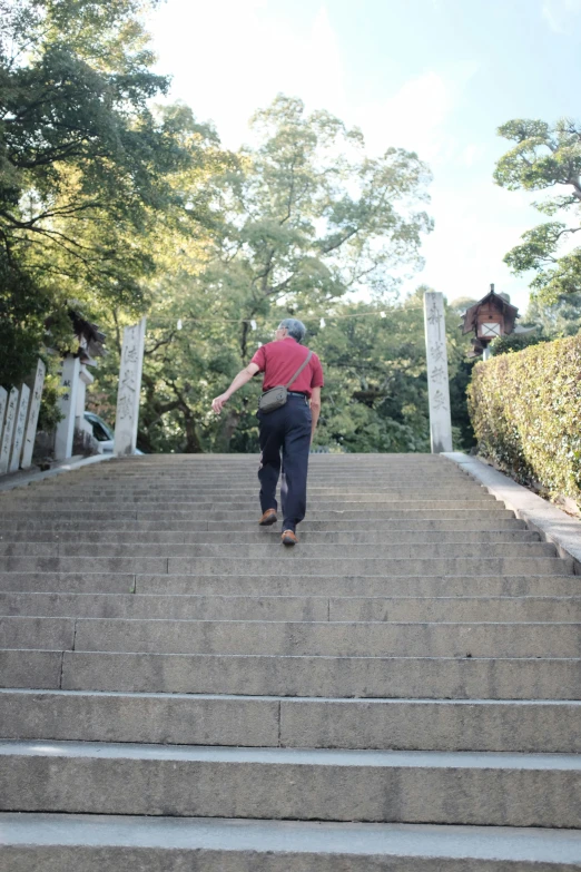 a man in red shirt running up some stairs