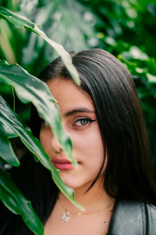 a woman standing under leaves in the shade