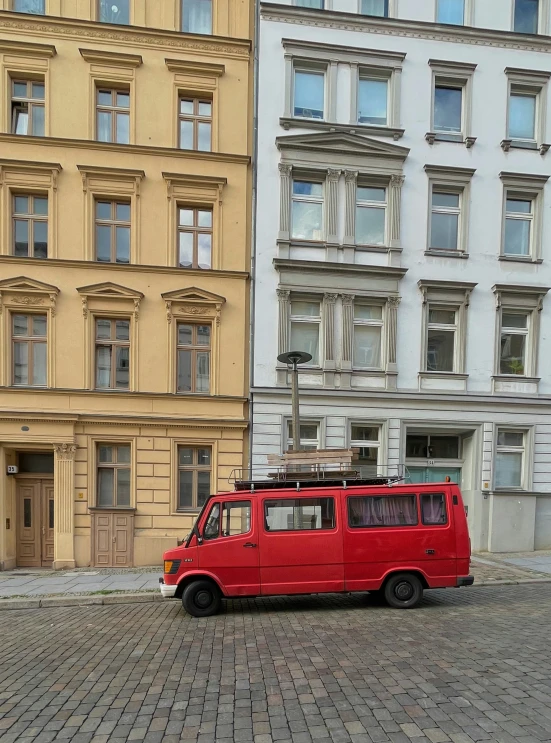 a small red van is parked in the street