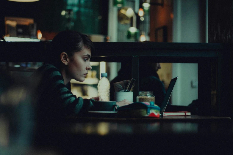 a person sitting at a table with a laptop