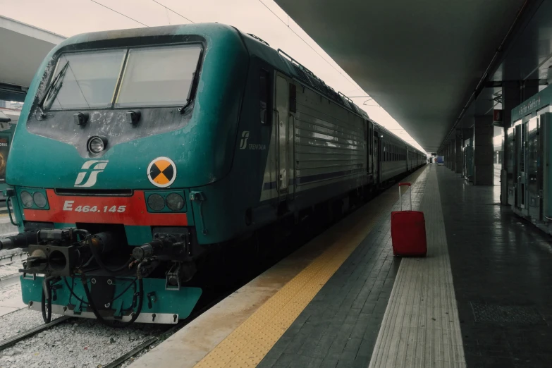 a blue train pulled into the station as people board it