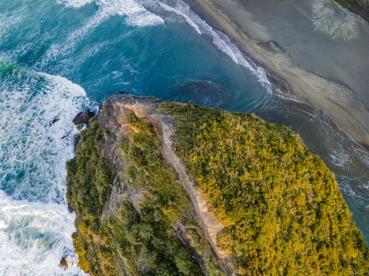 two people riding down the side of a cliff near the beach