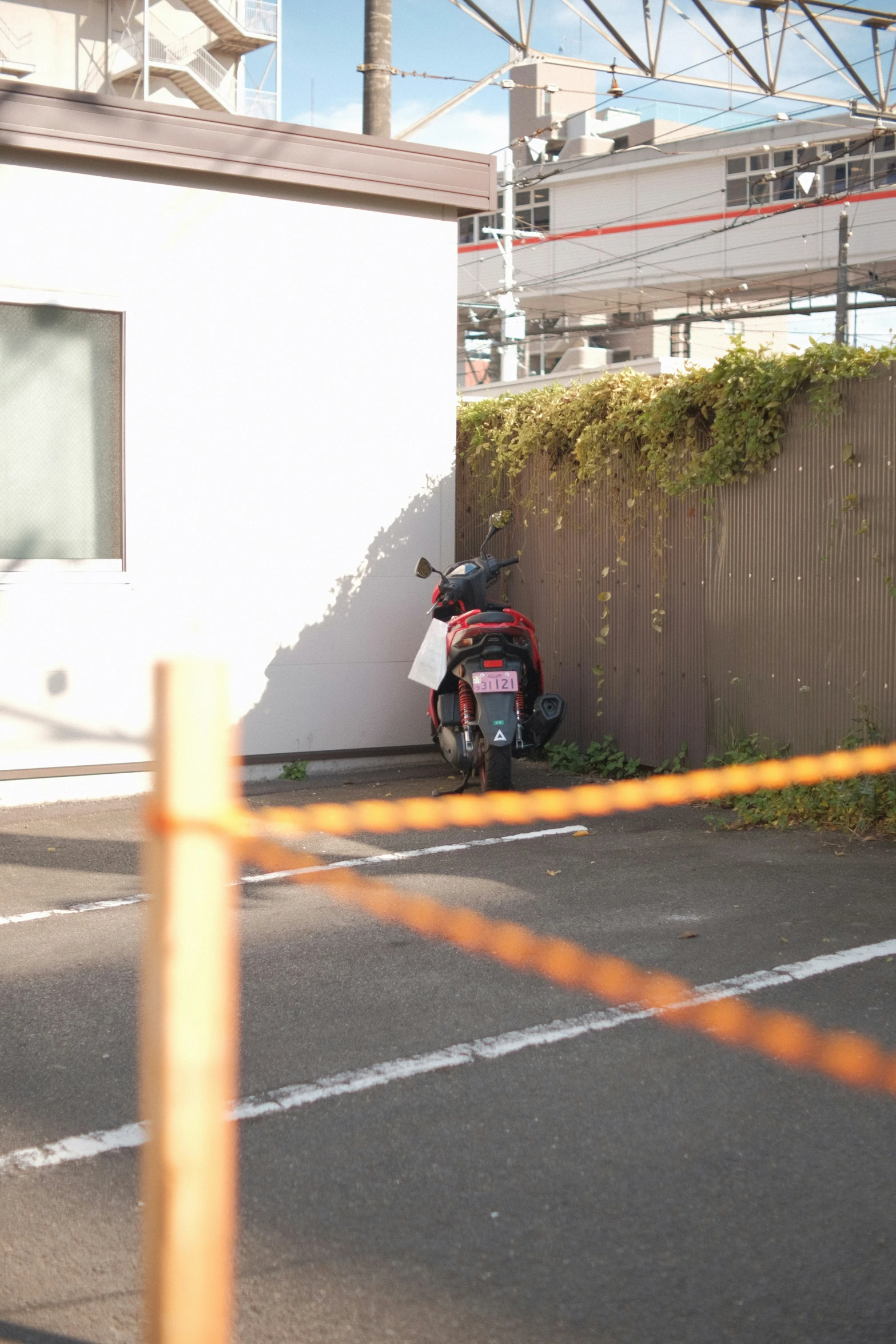 a motor scooter parked behind a fence and building