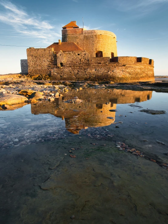 an old tower is on the shore and has water in it