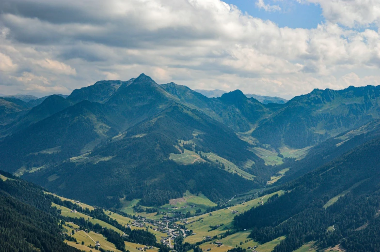 a valley with mountains in the background and a train on it