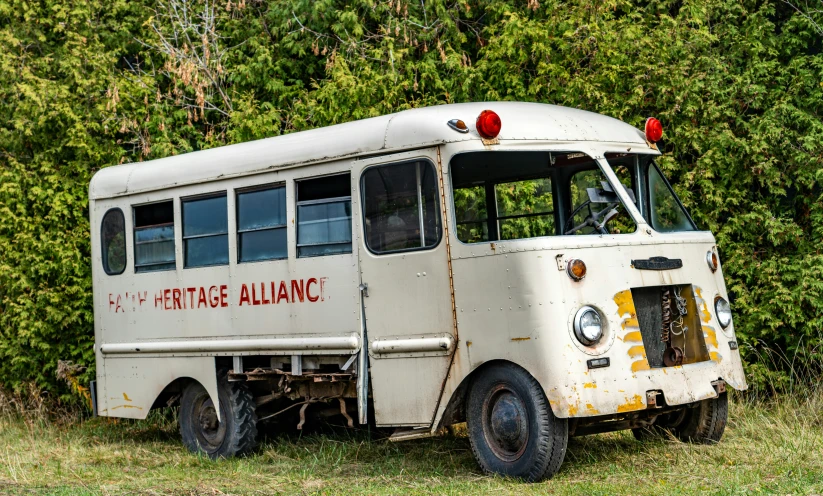 an old, damaged bus with trees in the background