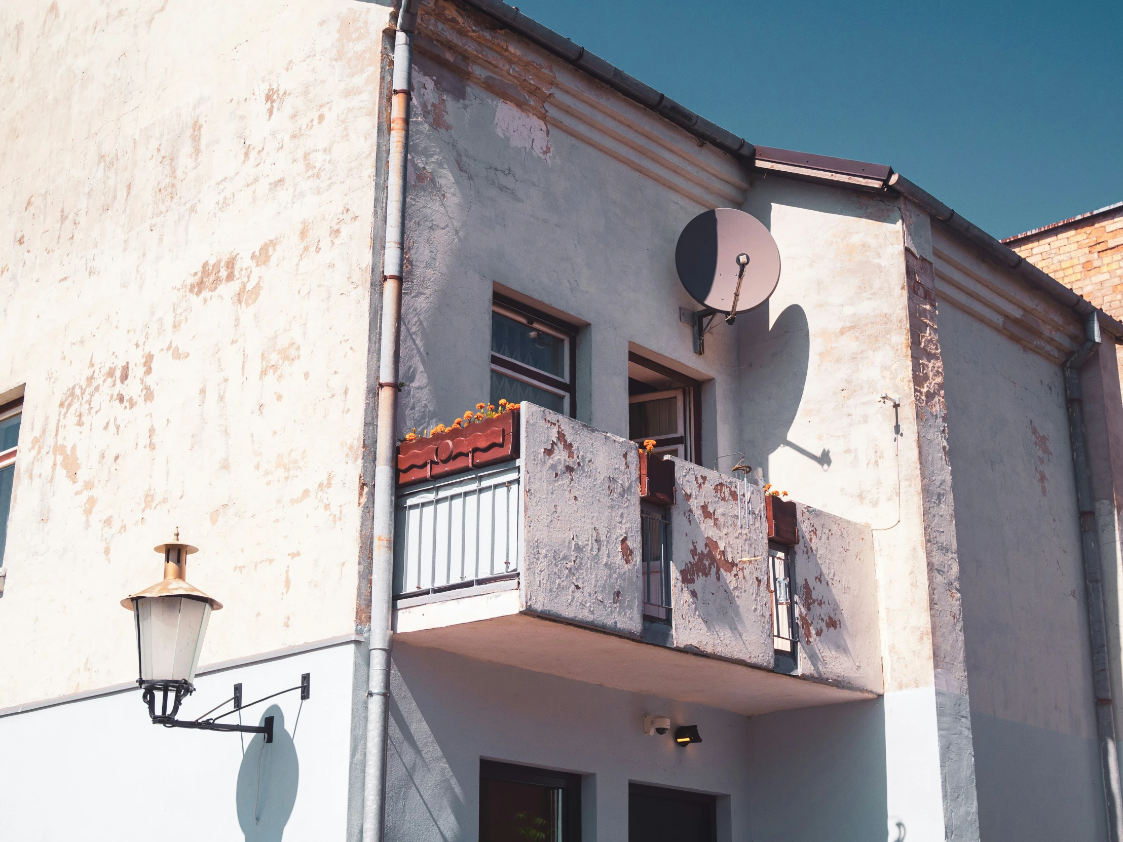 a grey building with a satellite dish on the corner