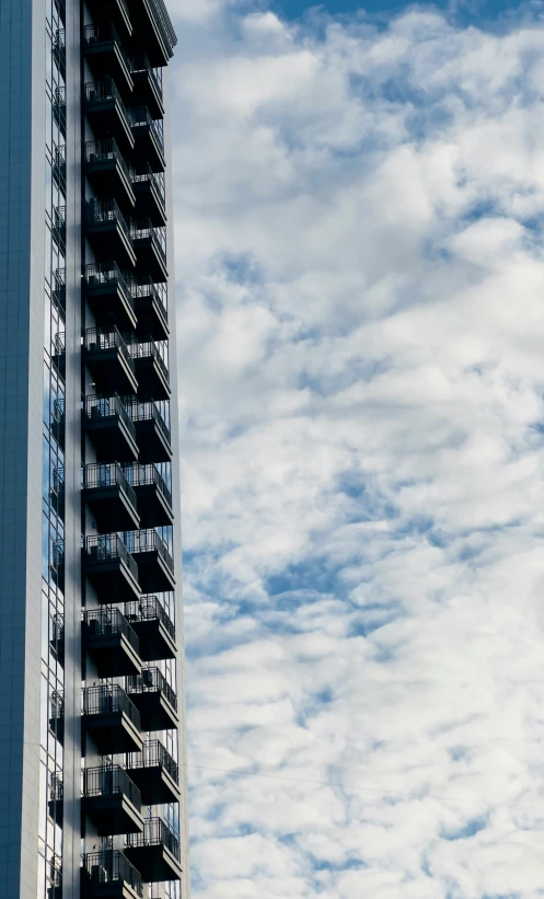 the airplane is flying in the blue sky above a tall building