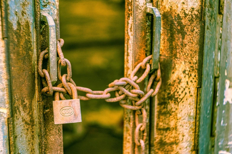 a rusty padlock door with a locked chain in the center