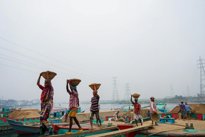 three people on boats with baskets on their heads